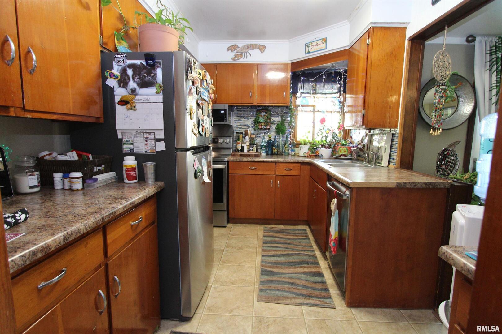 1330 Florence Avenue Clinton, IA 52732 - Photo 8 of 20 a kitchen with stainless steel appliances granite countertop a refrigerator a sink dishwasher and wooden cabinets with a dining table