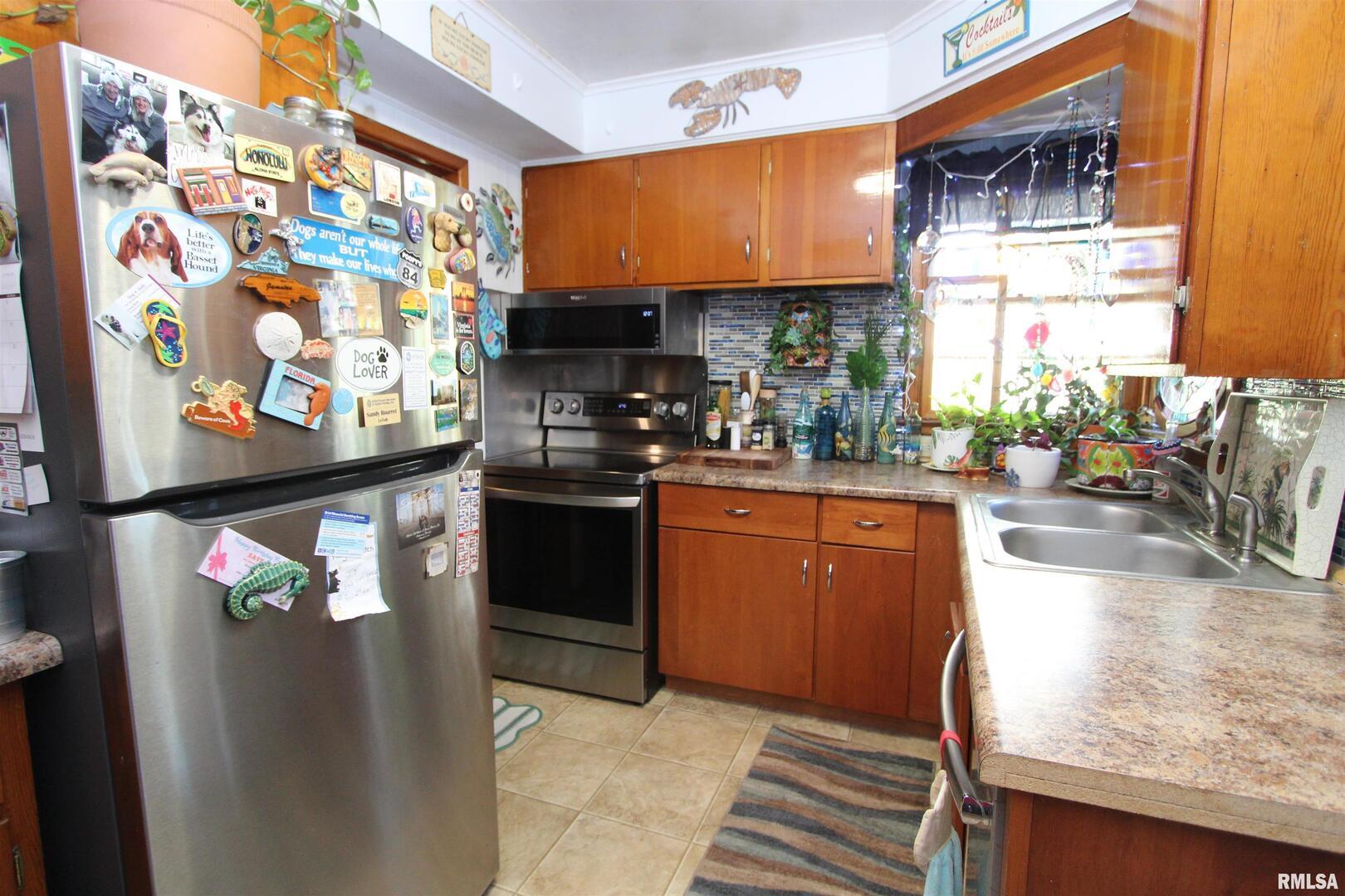 1330 Florence Avenue Clinton, IA 52732 - Photo 9 of 20 a kitchen with stainless steel appliances granite countertop a sink a stove and a refrigerator