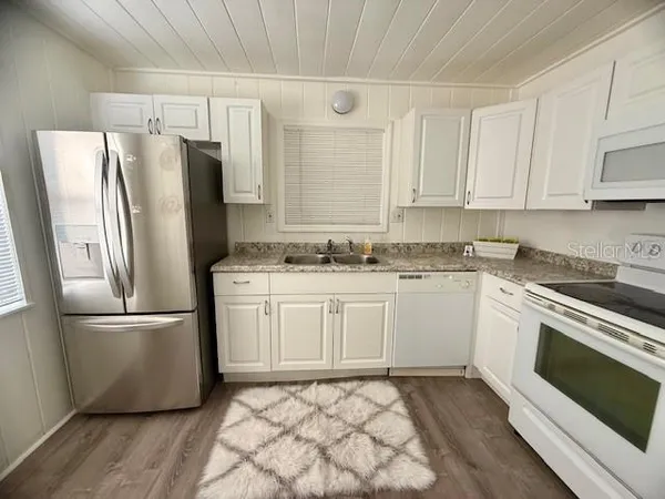 a kitchen with stainless steel appliances a refrigerator sink and microwave