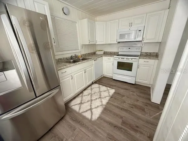 a kitchen with white cabinets and white appliances