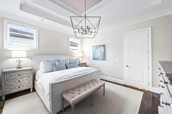 a bedroom with a bed and a chandelier