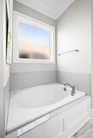 a bathroom with a bathtub and mirror