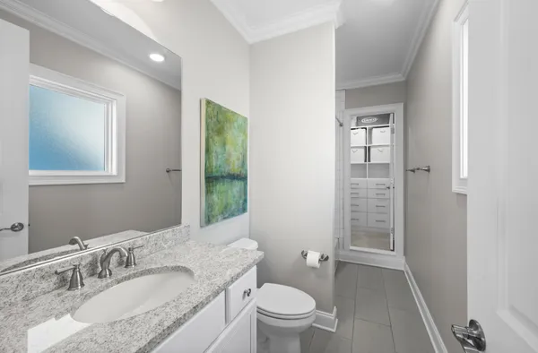 a bathroom with a granite countertop sink a toilet and shower