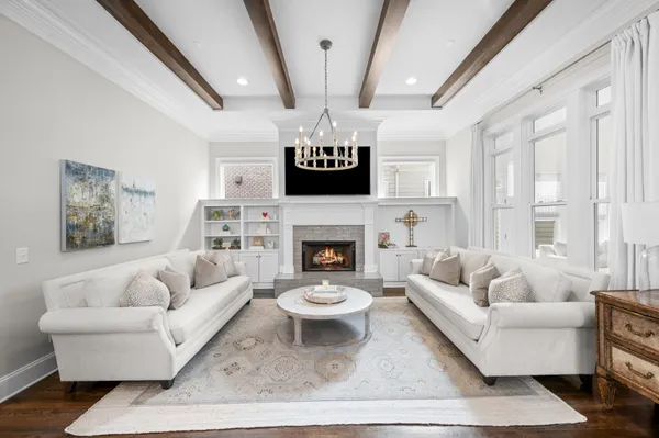 a living room with furniture a fireplace and a chandelier