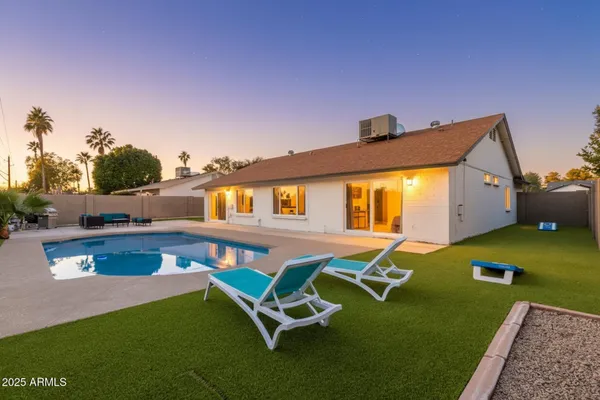 a front view of house with swimming pool yard fire pit and outdoor seating