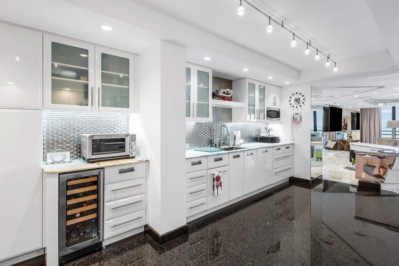 1500 South Ocean Boulevard, Unit 303/304 Boca Raton, FL 33432 - Photo 6 of 49 a kitchen that has a lot of cabinets a sink and appliances in it