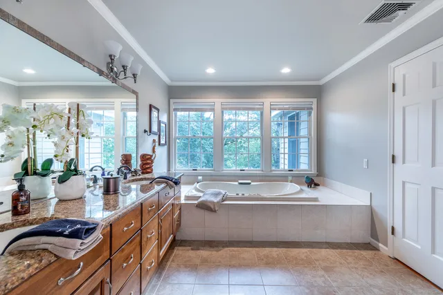 a spacious bathroom with a large tub and large windows