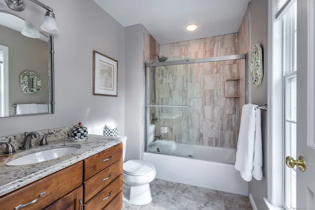 a bathroom with a granite countertop sink toilet and shower