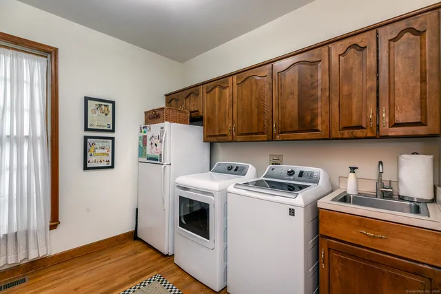 a view of a kitchen with fridge and wooden floor