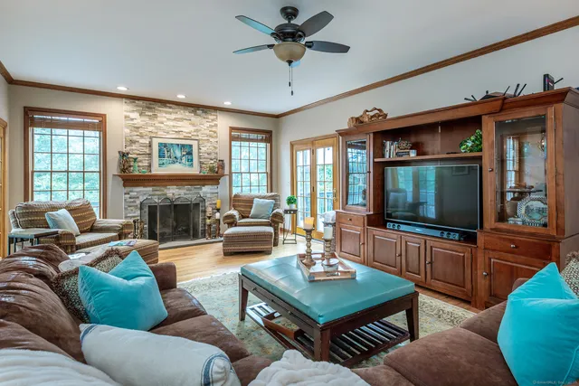 a living room with furniture a flat screen tv and a fireplace