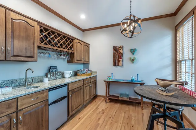 a kitchen with stainless steel appliances a table chairs in it and wooden floors