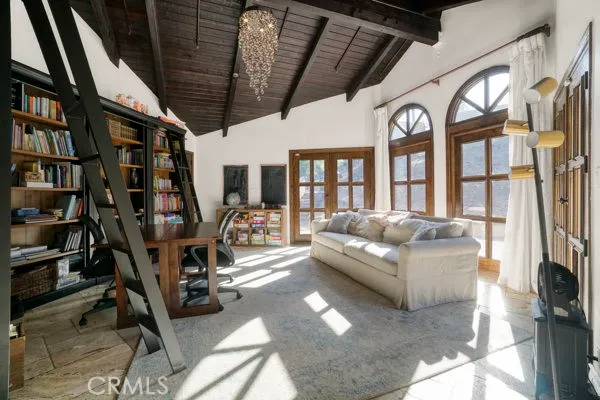 a living room with furniture a bookshelf and a large window