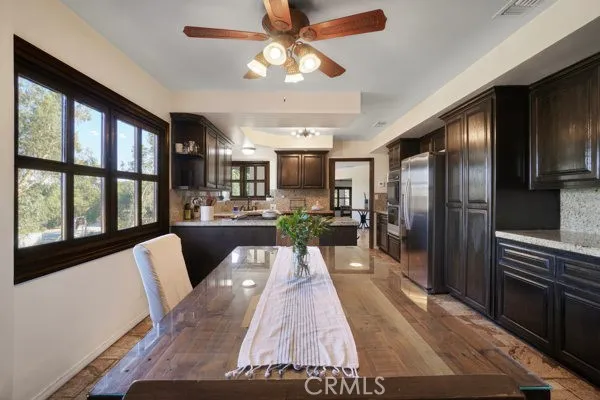 a view of a kitchen with furniture a kitchen appliances and a ceiling fan