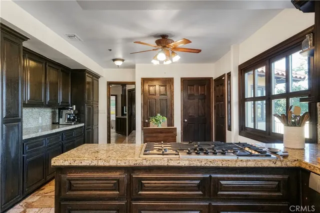 a kitchen with kitchen island granite countertop a stove a sink and a refrigerator