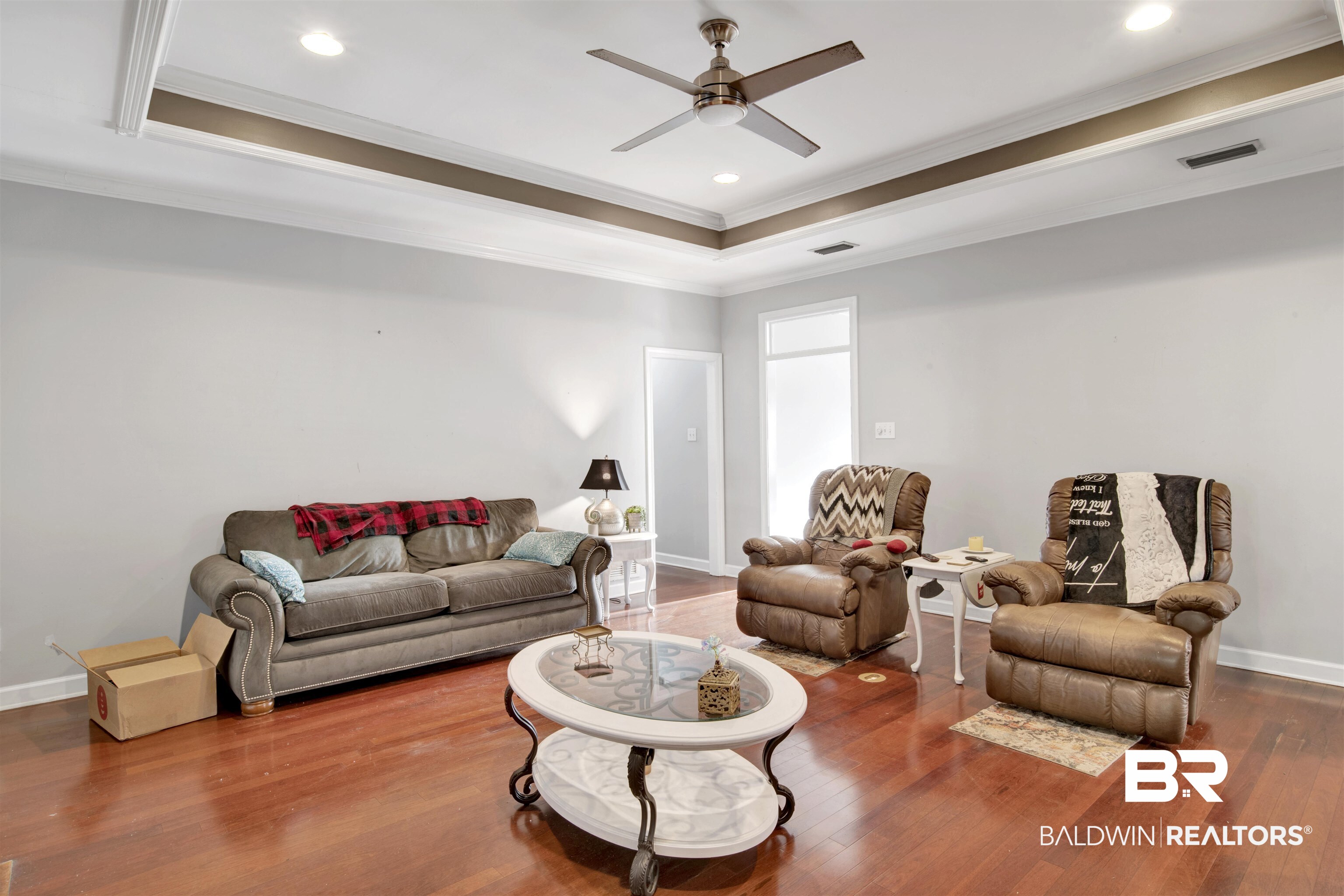 445 Wedgefield Drive South Mobile, AL 36608 - Photo 5 of 36 Living room with a tray ceiling, ornamental molding, and hardwood / wood-style flooring