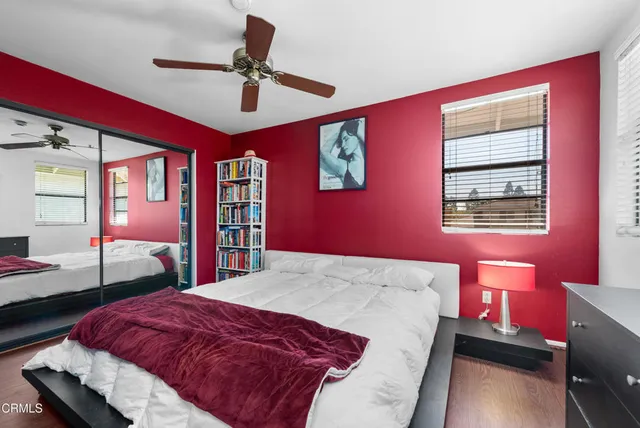 a bedroom with a bed and dresser with mirror