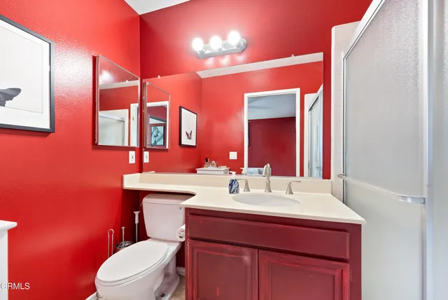 a bathroom with a sink vanity mirror and toilet