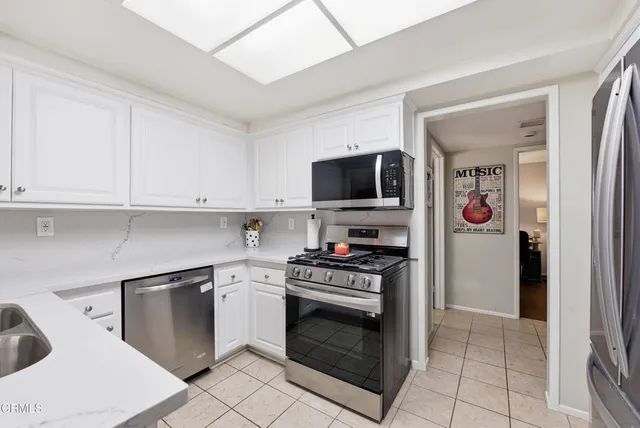 a kitchen with stainless steel appliances a stove a sink and a microwave