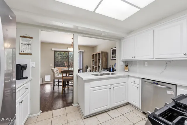 a kitchen with white cabinets and sink