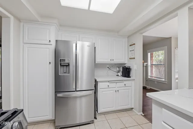 a kitchen with white cabinets and white stainless steel appliances