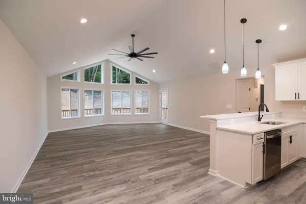 a view of a big room with wooden floor and windows