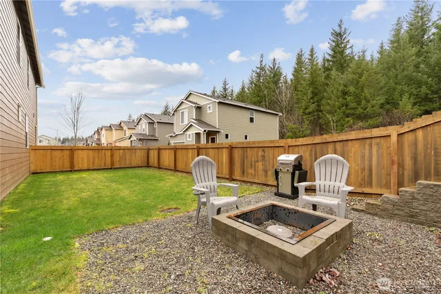 a backyard of a house with table and chairs