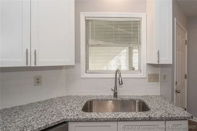 a kitchen with granite countertop a sink and a window