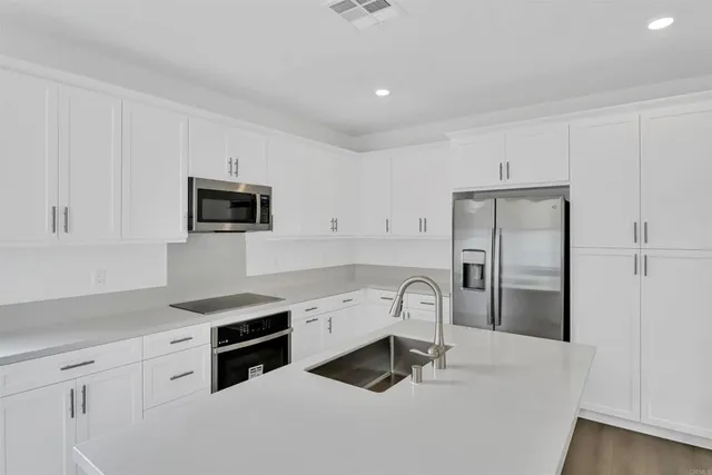 a kitchen with a sink a stove a refrigerator and cabinets