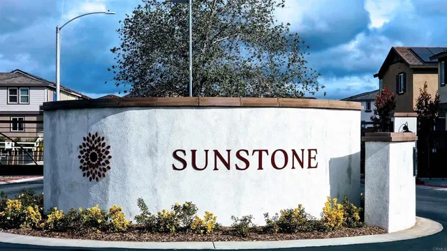 a street sign on a wall next to a road