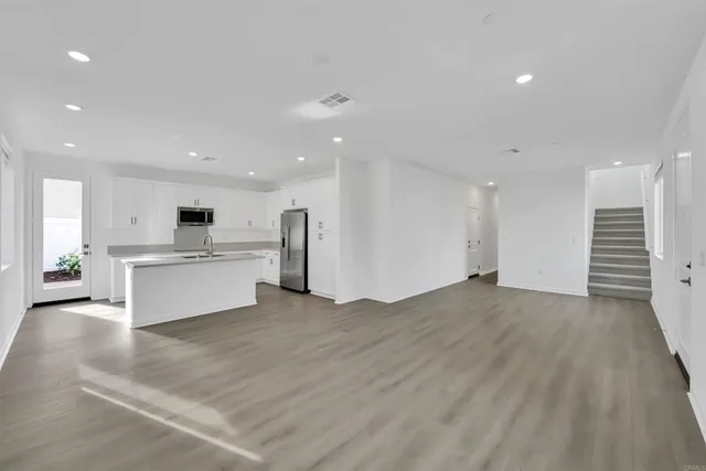 a large white kitchen with kitchen island a sink a stove and a refrigerator