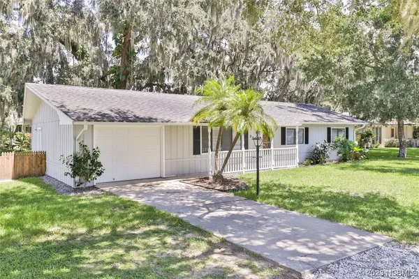 a front view of a house with a garden and yard