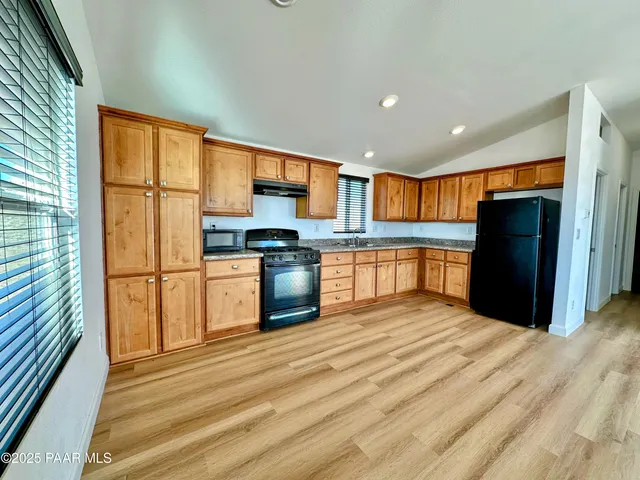 a kitchen with stainless steel appliances granite countertop a refrigerator and a stove top oven