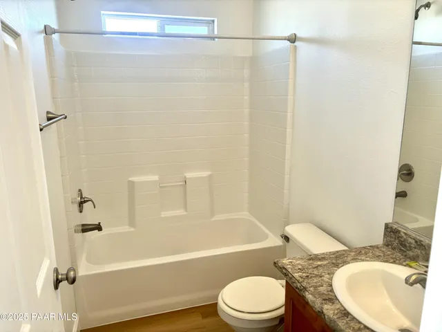 a bathroom with a granite countertop toilet sink and shower