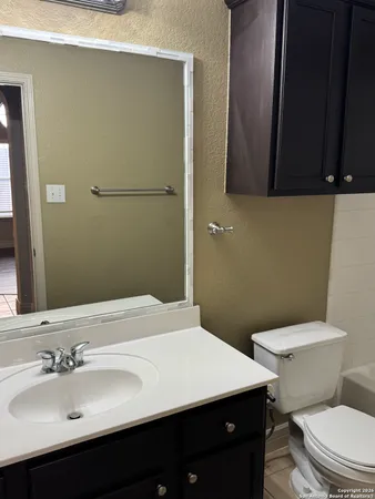 a bathroom with a sink a toilet and mirror