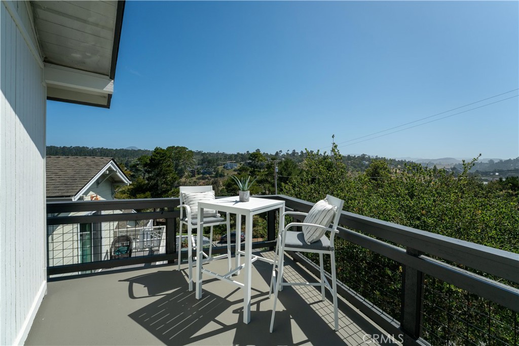 675 Huntington Road Cambria, CA 93428 - Photo 21 of 30 a view of a patio with table and chairs with wooden floor and fence