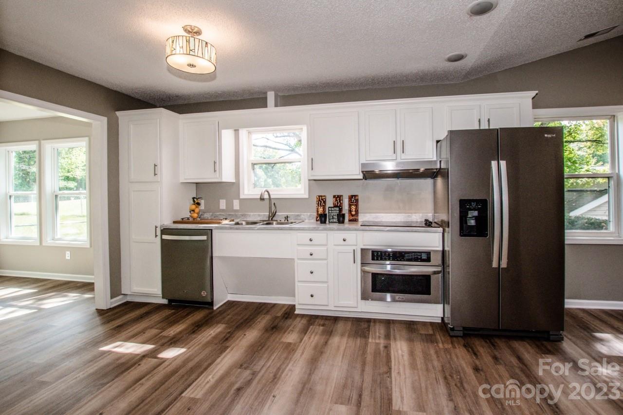 179 Isle Of Pines Road Mooresville, NC 28117 - Photo 2 of 25 a kitchen with a refrigerator and white cabinets