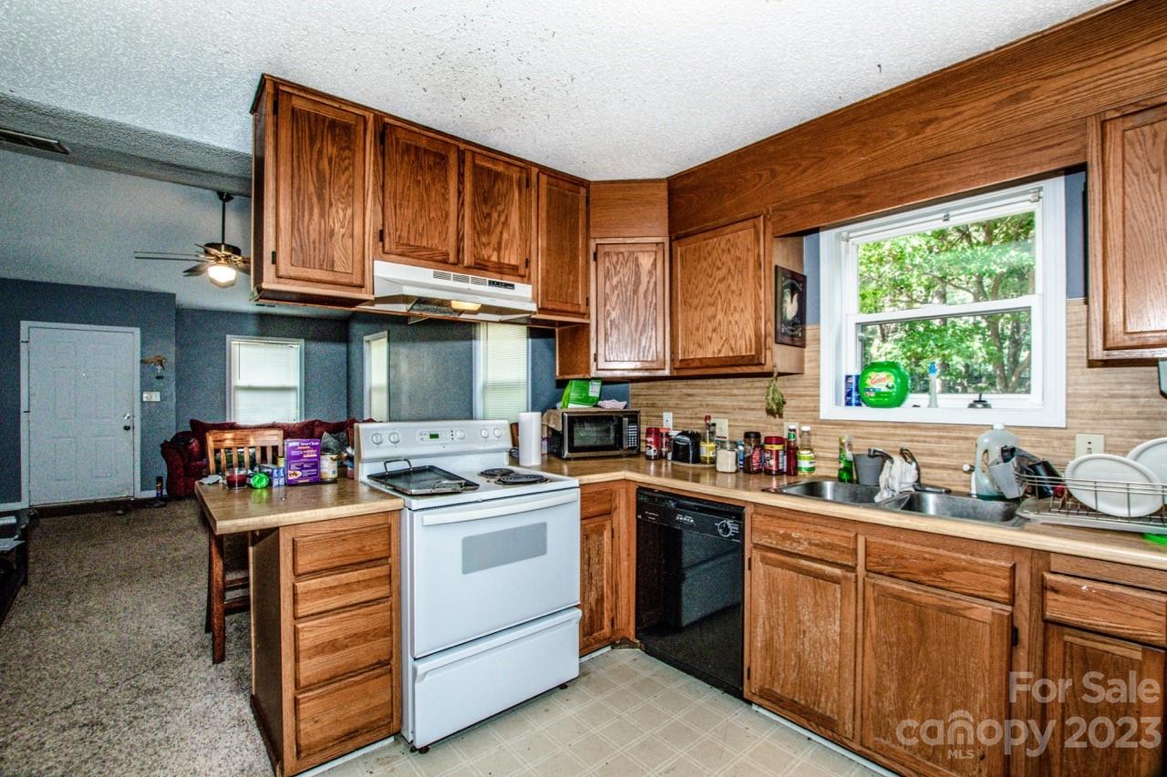 179 Isle Of Pines Road Mooresville, NC 28117 - Photo 21 of 25 a kitchen with a stove top oven sink and cabinets