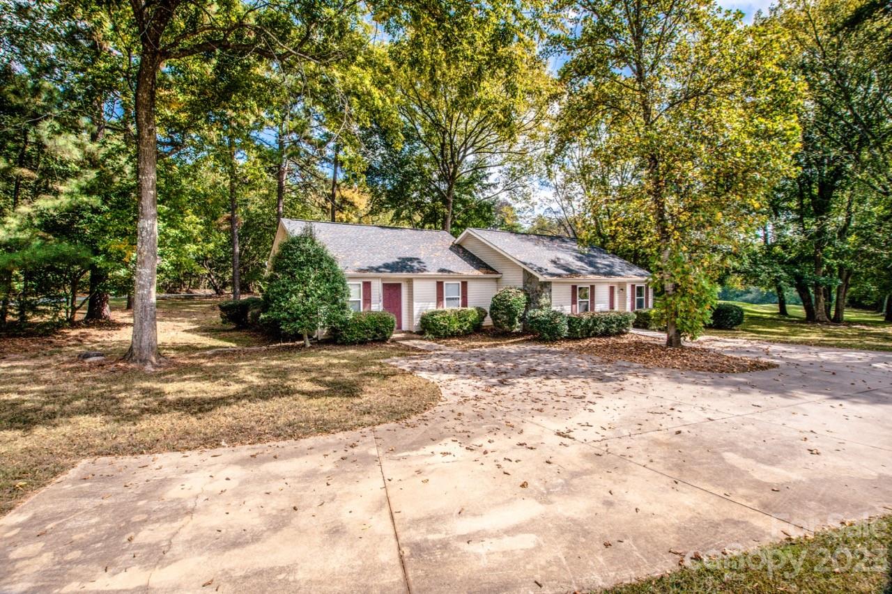 179 Isle Of Pines Road Mooresville, NC 28117 - Photo 23 of 25 a front view of a house with a dirt yard and a large tree