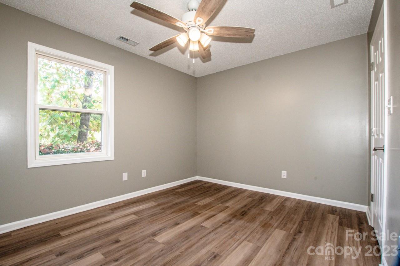 179 Isle Of Pines Road Mooresville, NC 28117 - Photo 10 of 25 an empty room with wooden floor and windows