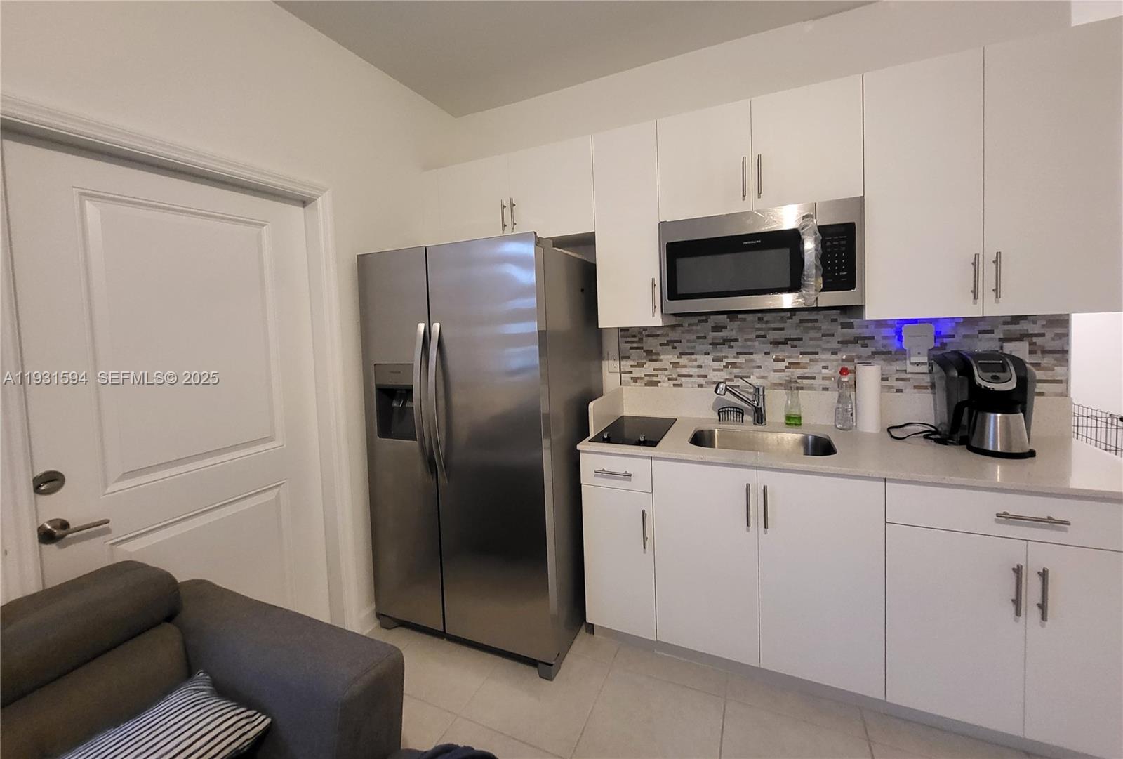 a kitchen with stainless steel appliances a refrigerator sink and microwave