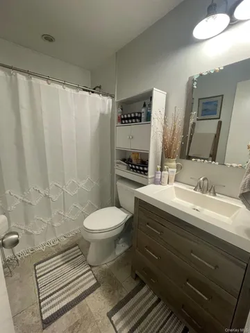 a bathroom with a granite countertop toilet and a sink