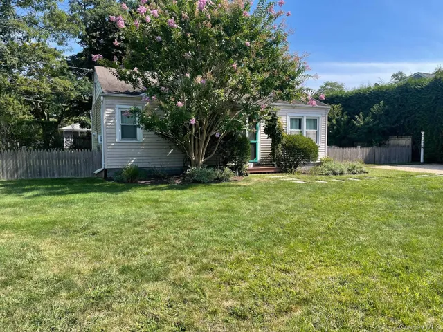 a view of a house with a yard and sitting area
