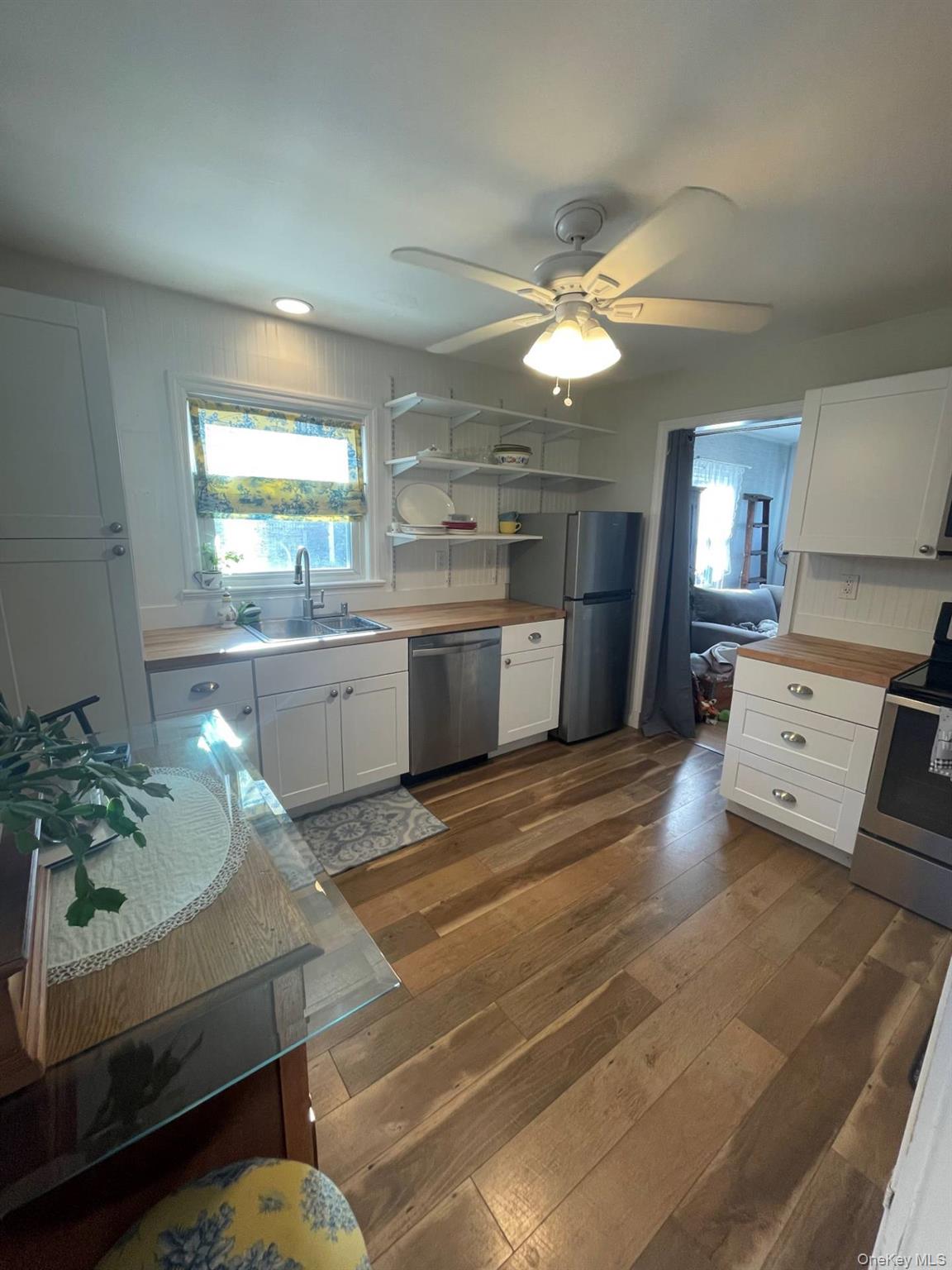 30 Maple Street Westhampton Beach, NY 11978 - Photo 7 of 14 Kitchen featuring white cabinetry and open shelves, stainless steel appliances. Lots of natural light!