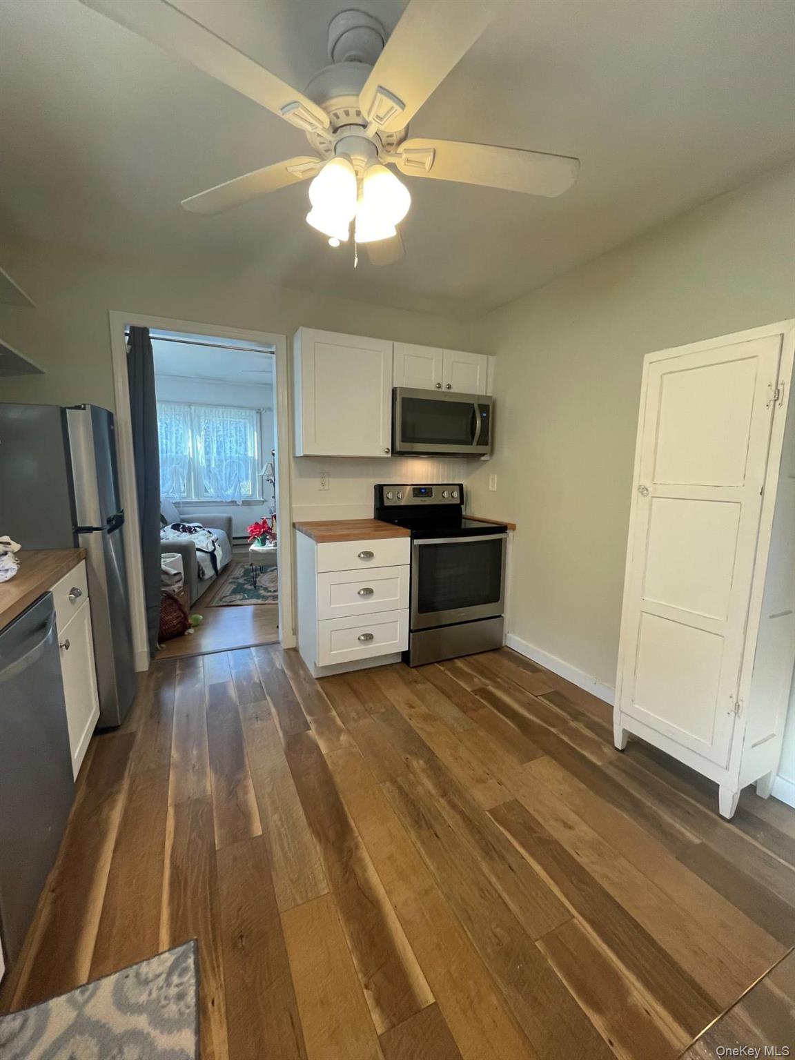 30 Maple Street Westhampton Beach, NY 11978 - Photo 8 of 14 Kitchen with white cabinets & stainless steel appliances,