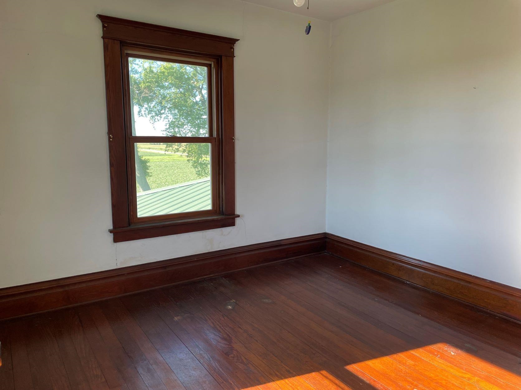 3076 Alworth Road Winnebago, IL 61088 - Photo 12 of 28 a view of an empty room with wooden floor and a window