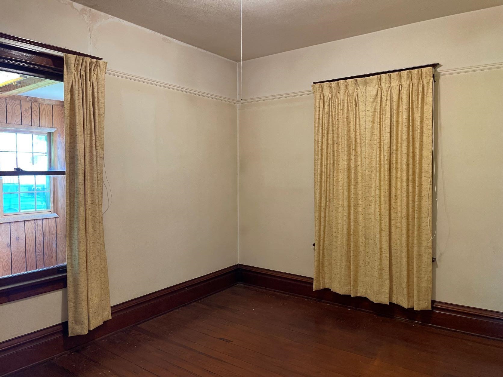 3076 Alworth Road Winnebago, IL 61088 - Photo 14 of 28 an empty room with wooden floor and windows with curtains
