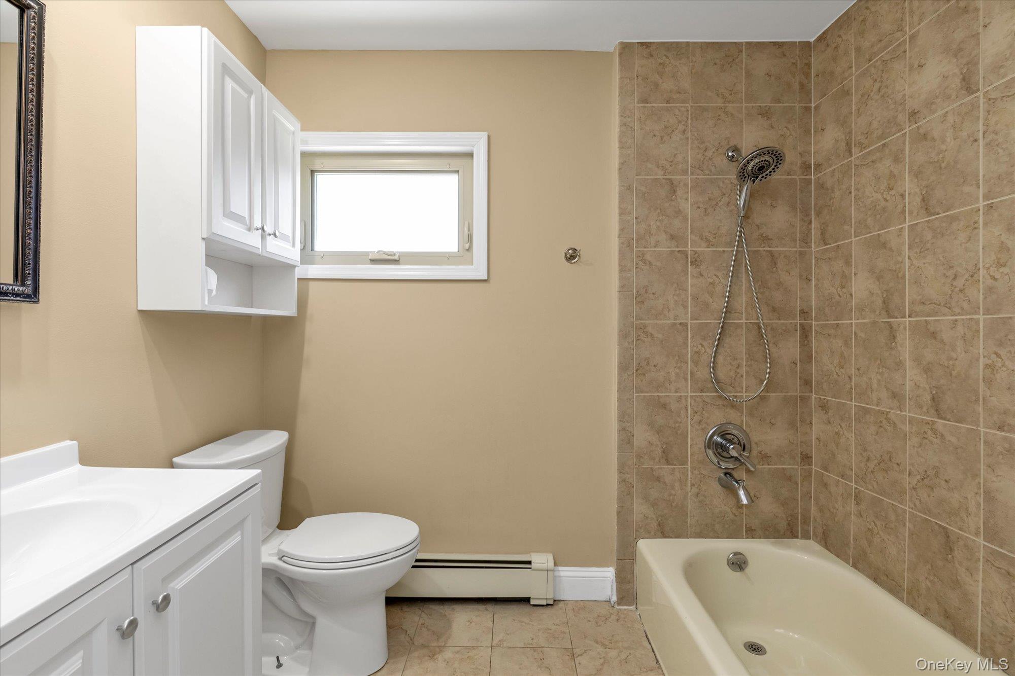 4 Rose Street, Unit 5H1 Oceanside, NY 11572 - Photo 12 of 18 a bathroom with a toilet a sink a mirror and bathtub