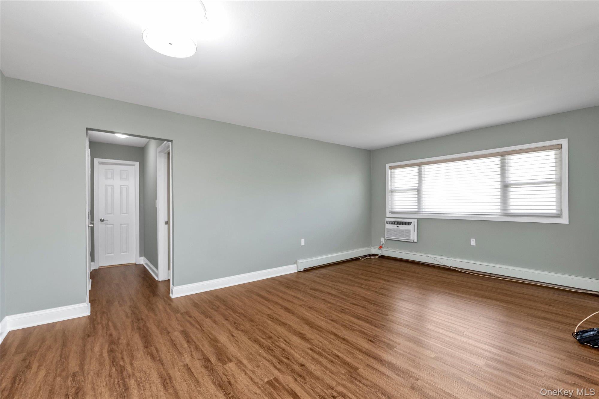4 Rose Street, Unit 5H1 Oceanside, NY 11572 - Photo 2 of 18 an empty room with wooden floor and windows