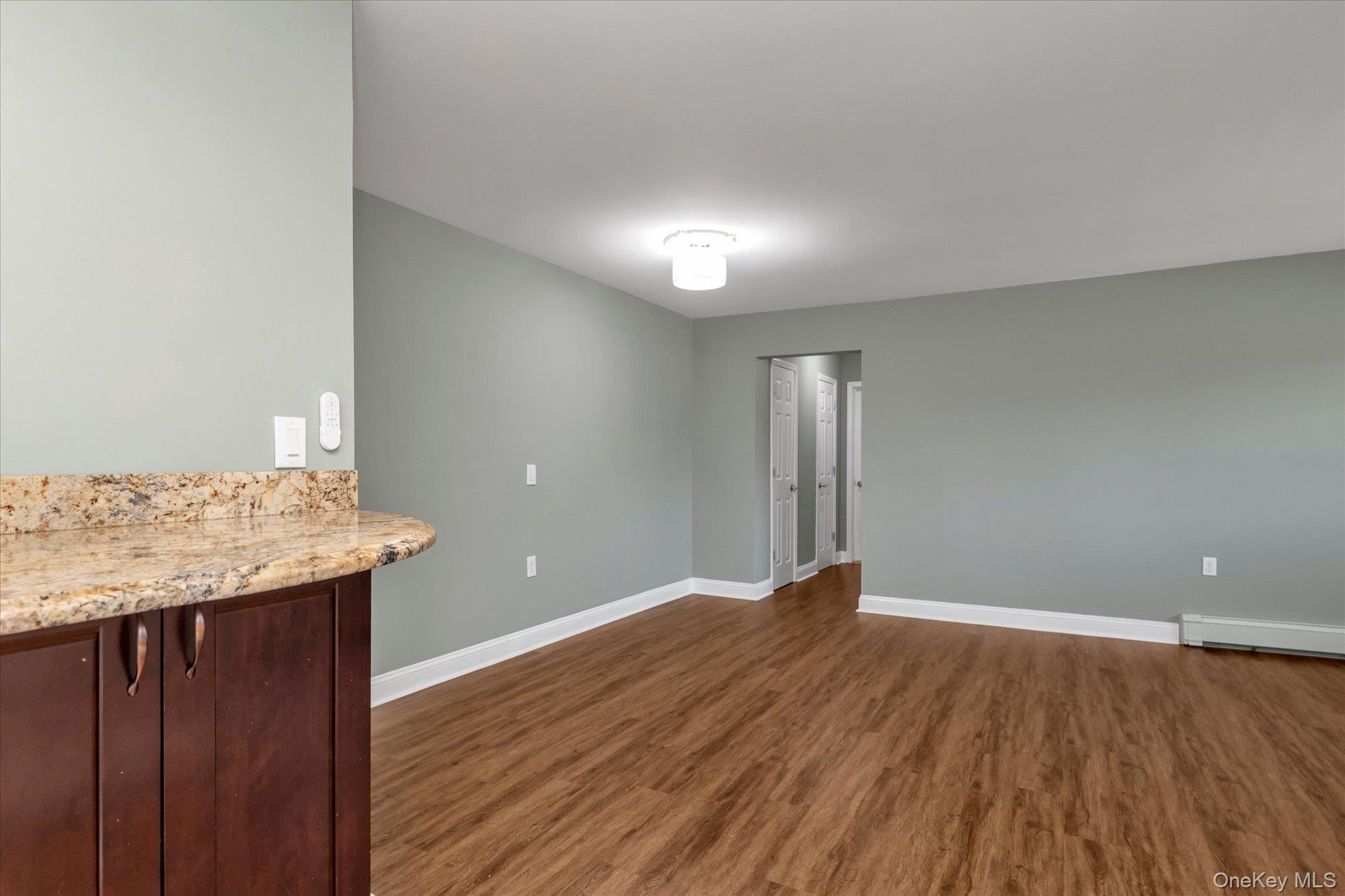 4 Rose Street, Unit 5H1 Oceanside, NY 11572 - Photo 6 of 18 an empty room with wooden floor and natural light