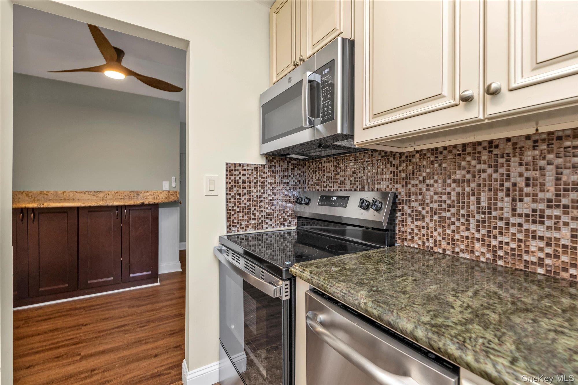 4 Rose Street, Unit 5H1 Oceanside, NY 11572 - Photo 9 of 18 a kitchen with granite countertop cabinets stainless steel appliances and a counter space